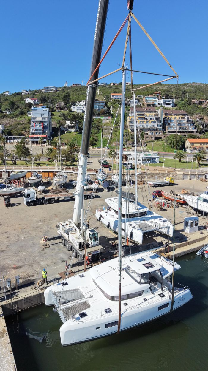 Grúa móvil Rosano realizando izaje de velero en dársena portuaria, Uruguay