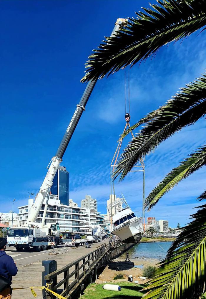 Grúa Rosano trabajando junto a velero en marina deportiva, Uruguay