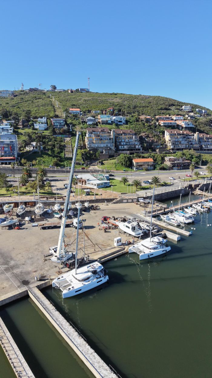 Grúa Rosano en operativo de izaje en muelle con vista al cerro, Uruguay